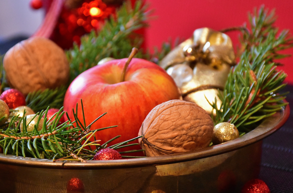 Photo of bowl of nuts and an apple for staying healthy during the holidays